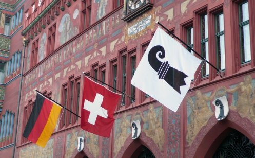 The Basel, Swiss and  German flags fluttering outside Basel City Hall. 