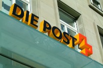Die Leuchtschrift der Post an einer Hausfassade in Basel.