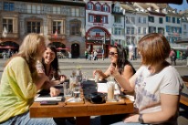 Four women chatting in a restaurant.